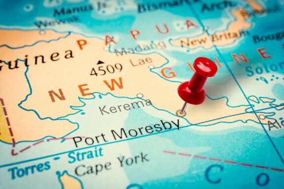Map Pin on Port Moresby Location Port Moresby, the capital of New Guinea highlighted by a pin on a map.