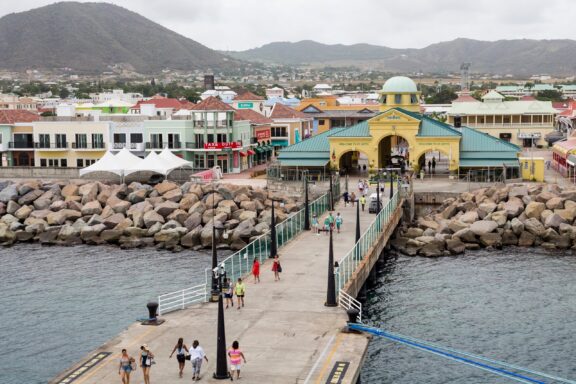 Port Zante Pier with People and Colorful Buildings Port Zante, a focal point for shopping and entertainment in Basseterre
