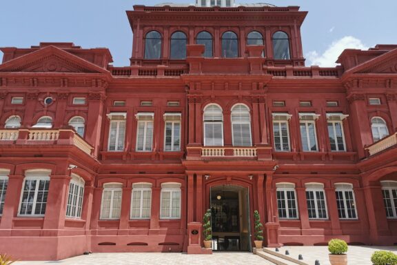 Red Colonial Building Facade Under Blue Sky The Red House, the seat of the Parliament since 1907
