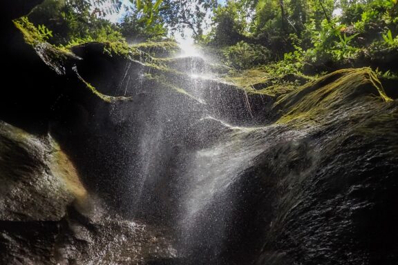 Sunlit Waterfall in Lush Forest Titou Gorge, formed by volcanic activity, is a narrow canyon with crystal-clear waters
