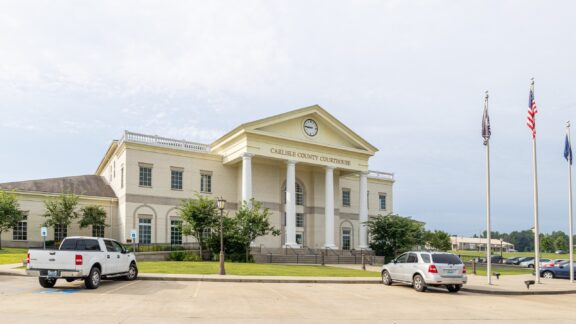 A street-level view of the Carlisle County Courthouse facade in Bardwell, Kentucky.