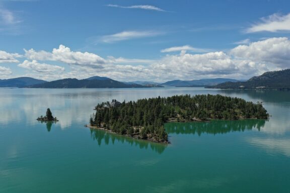 A view of still water surrounding an island in Flathead Lake, Montana.