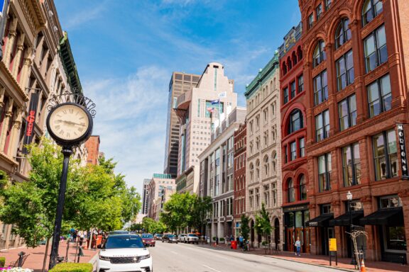 A street-level view of downtown Louisville, Kentucky on a sunny day.