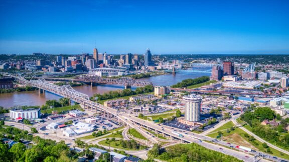 An aerial view of the Ohio River as it passes between Covington, Kentucky and Cincinnati, Ohio on a sunny day.