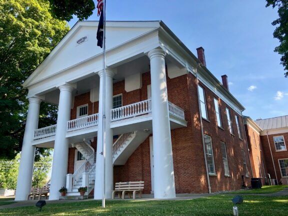 A low-angle view of the facade of the Ohio County Courthouse in Rising Sun, Indiana.