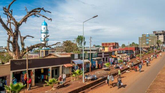 People and shops line a road in Wolaita Sodo, Ethiopia on a sunny day.