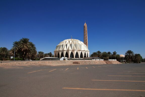 Dome and Minaret of Al-Nilain Mosque Against Blue Sky Al-Nilein Mosque, notable for its modern architectural style