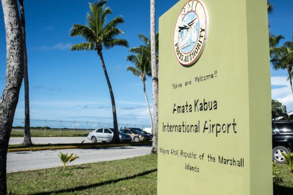 Signboard of Amata Kabua International Airport with Palm Trees Amata Kabua Airport, originally constructed during World War II by Japanese forces