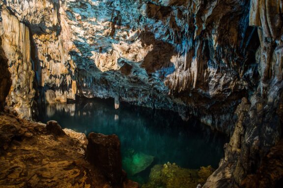 Underground Cave Pool with Stalactites Anahulu Cave, featuring stunning limestone formations and an underground pool