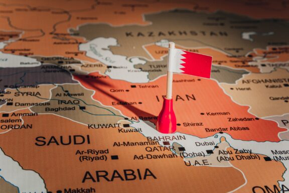 A Bahrain flag pin placed on Bahrain's location on a world map.