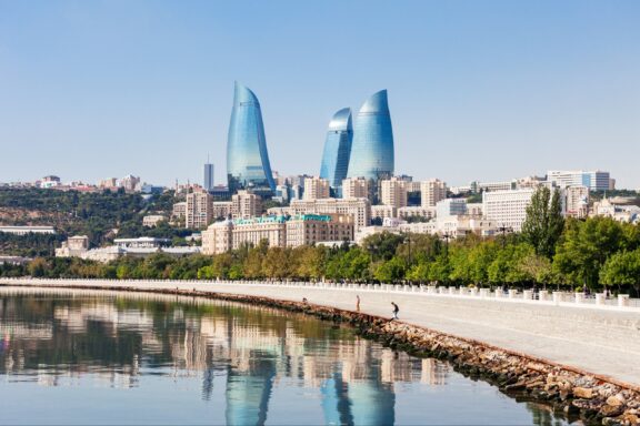 Baku’s Flame Towers stand in the distance, with the Caspian Sea in the foreground.