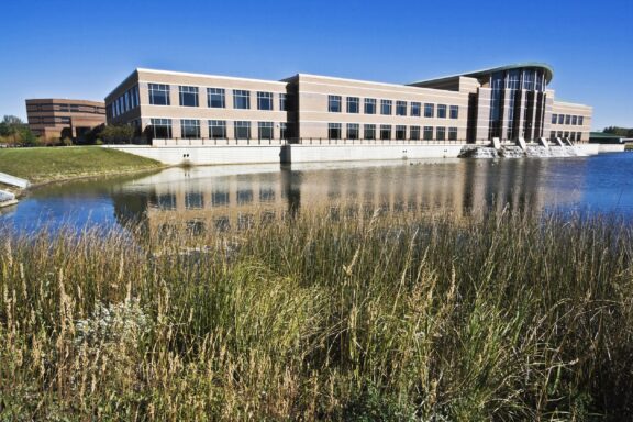 A view of the DuPage County Administration Building sitting next to water.