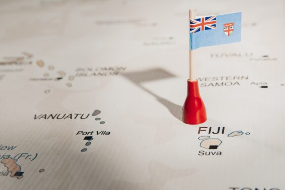 A map pin with the flag of Fiji placed on Suva, the capital city, on a map.