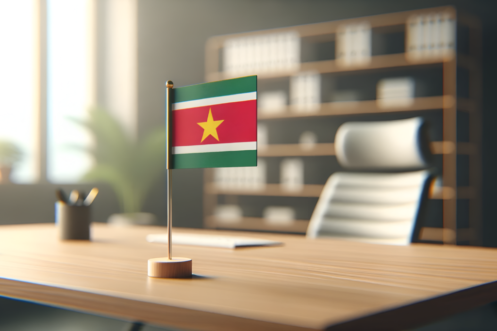 Flag of Suriname on a desk with a blurred office background.