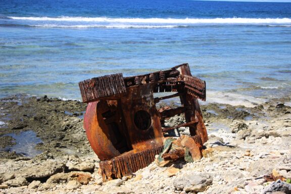 Rusty WWII Relic on Tropical Shoreline WW2 Remnants in Funafuti, a stark reminder of Funafuti's strategic role in World War II