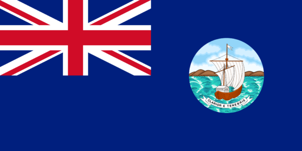 Flag of Grenada with a Union Jack in the upper left corner and a badge featuring a sailing ship in the center on a blue background.