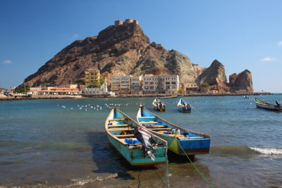 Two small, colorful boats float in the water at the Port of Aden in Yemen.