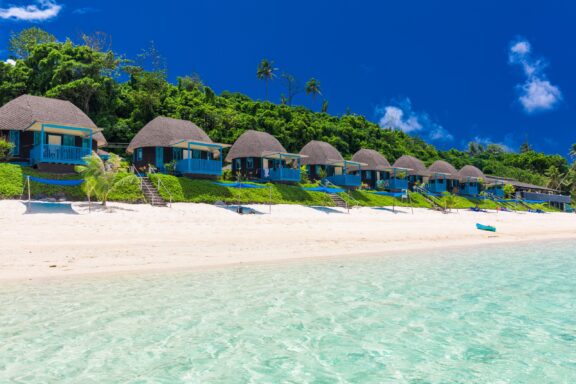Tropical Beach with Overwater Bungalows Lalomanu Beach, often cited as one of the most beautiful in the South Pacific