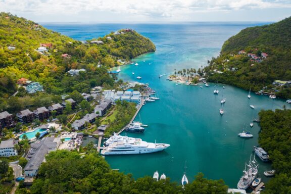 Aerial View of Marigot Bay with Boats and Surrounding Greenery Marigot Bay, often cited as one of the most beautiful bays in the Caribbean