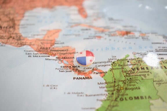 A pin with the flag of Panama placed on Panama's location on a world map.