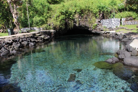 Serene Cave Pool Surrounded by Lush Greenery Piula Cave Pool, famous for its crystal-clear waters