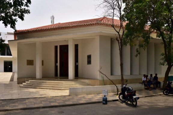 Exterior View of a Museum Building with Visitors Seated Under Shade Timor-Leste Resistance Archive and Museum