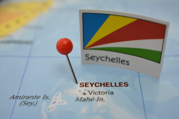 A pin flag of Seychelles placed on a map, indicating the location of the country.