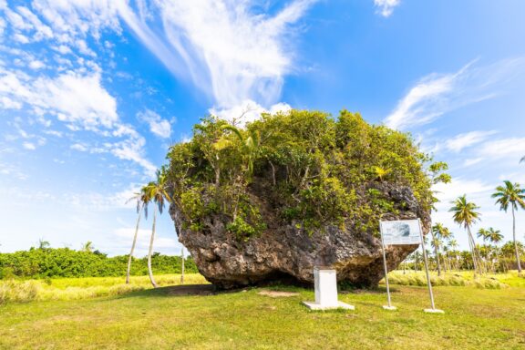 Boulder with Vegetation Under Blue Sky Tsunami Rock, which local legends indicate that its placement is the result of a tsunami