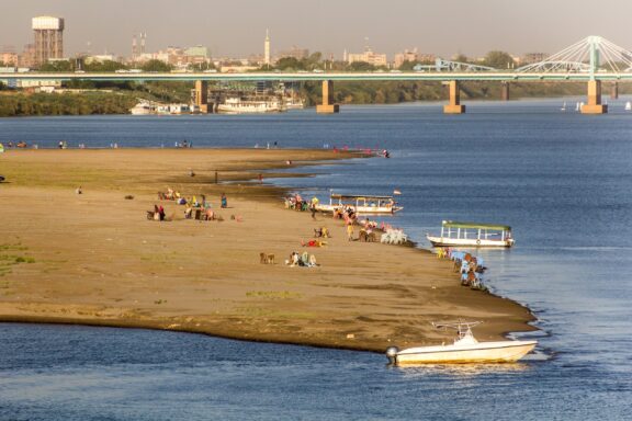 Riverbank Beach with People and Boats Beach on the Tuti Island