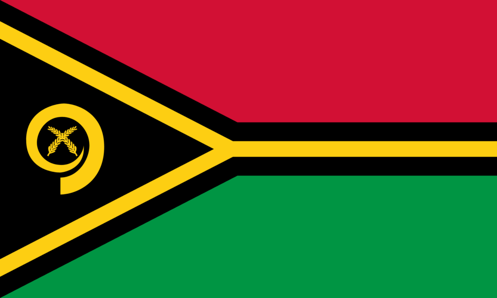 Flag of Vanuatu with a red field over a green field, separated by a black triangle with yellow fringe emanating from the hoist side, featuring a yellow emblem of a boar's tusk encircling two crossed namele leaves.