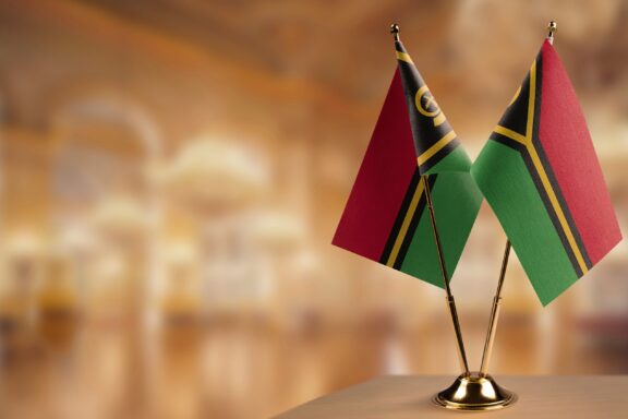 Two Vanuatu Flags on Stand Two small Vanuatu flags on stands against a blurred background.