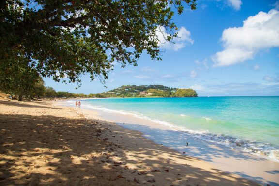 Tropical Beach with Clear Blue Water and Walking Couple Vigie Beach, offering stunning views of the island's lush landscape