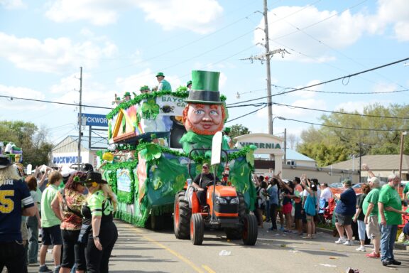 A parade float driven by a tractor makes its way down a crowded street in Metairie, Louisiana on Saint Patrick’s Day.