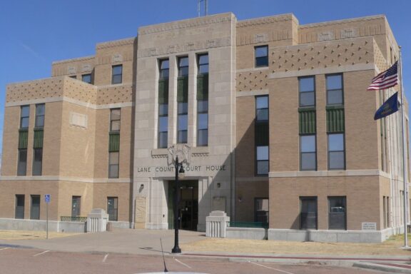 A street-level view of the entrance to the Lane County Courthouse in Dighton, Kansas on a sunny day.