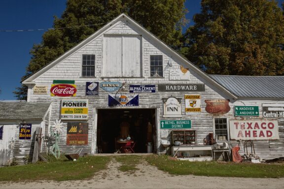 A low-angle view of the façade of the Steam Mill Antiques Shop in Bethel, Maine.