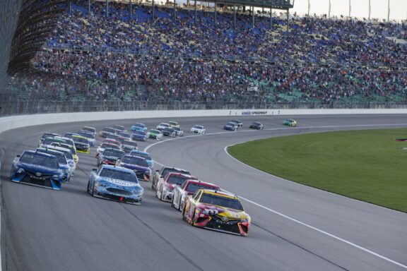 Crowds cheer as cars race on the Kansas Speedway in Kansas City.