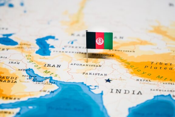 A pin with the flag of Afghanistan placed on a map, indicating the country's location.