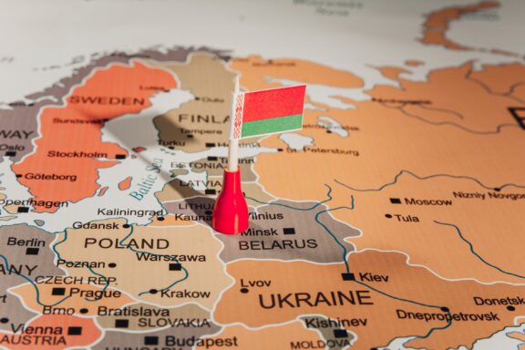 A pin with the Belarus flag placed on Minsk, Belarus, on a map of Europe.