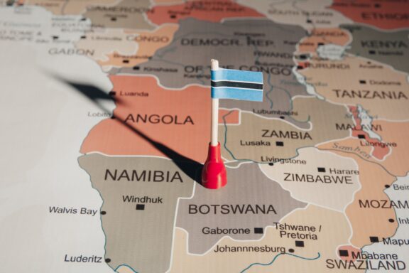 A Botswana flag pin placed on Gaborone on a map of southern Africa.