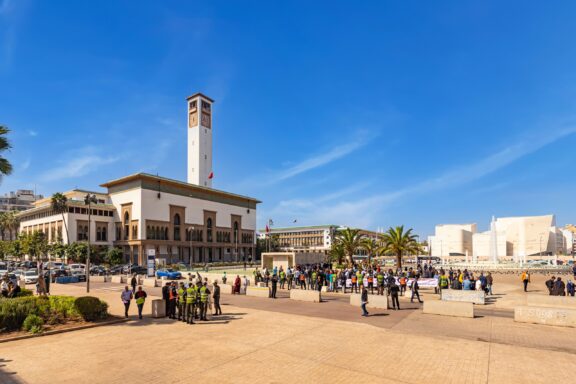 People gather in a central square on a sunny day in Casablanca, Morocco.