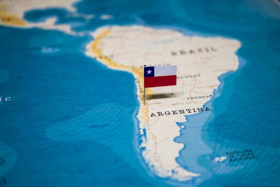 A pin with the flag of Chile placed on a map, indicating the location of Chile in South America.