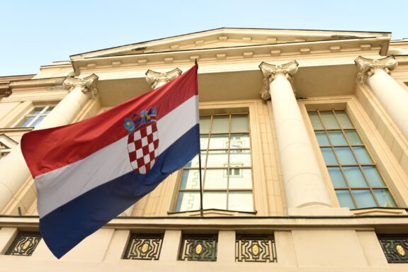 Croatian flag waving in front of the parliament building.