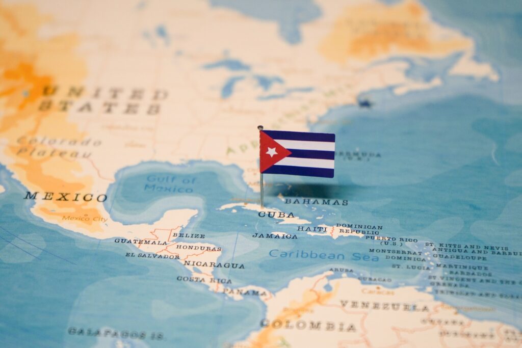 A Cuban flag pin placed on Cuba on a world map.