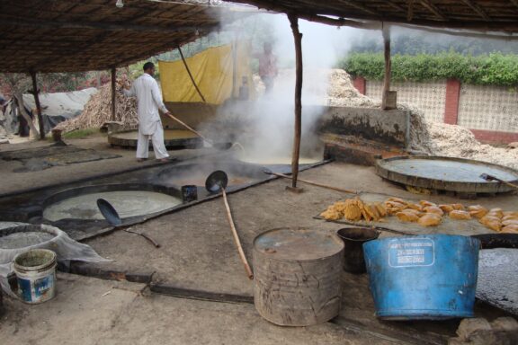 A man makes jaggery at an outdoor factory in Firozabad, India.