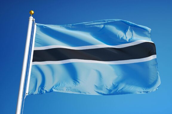 Flag of Botswana waving against a clear blue sky.