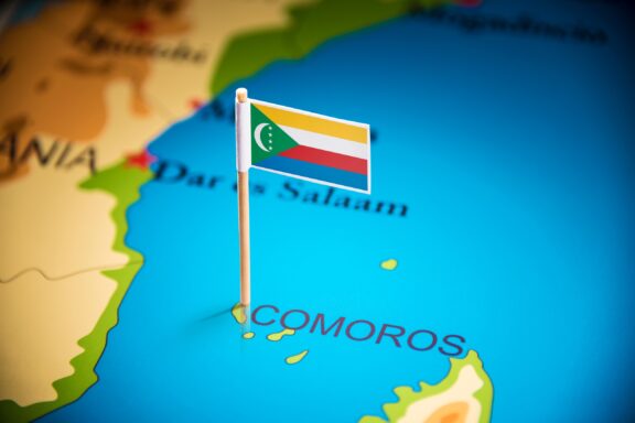 A pin with the flag of Comoros placed on a map at the location of the Comoros Islands.