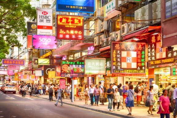 People walk under neon lights along Hong Kong’s Tsim Sha Tsui street.