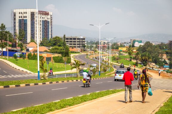 Urban Scene of Kigali, Rwanda with Pedestrians and Traffic on a Sunny Day People walk along a road on the outskirts of Kigali, Rwanda.