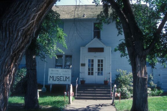 Trees line the walkway to the former McLean County Courthouse in Washburn, North Dakota.