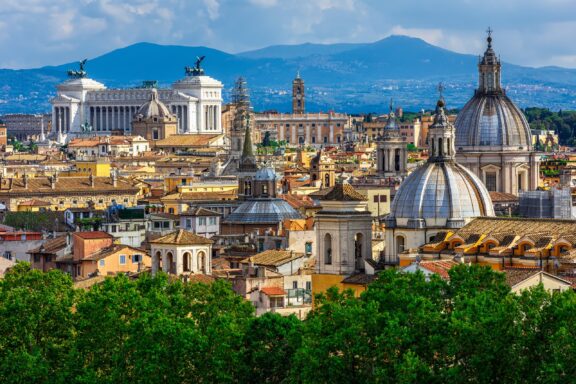 A view of hills in the distance beyond the skyline of Rome in Italy, one of the richest countries in Europe.